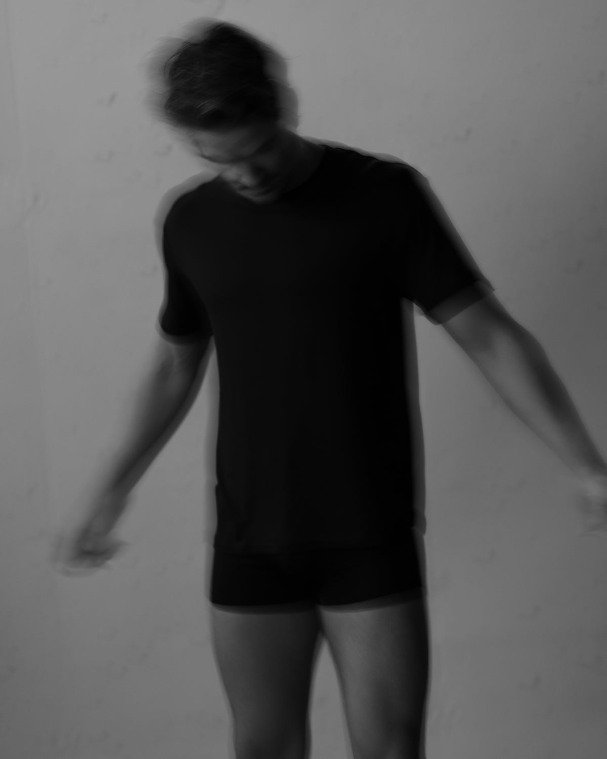 Mann in schwarzem SEACELL T-Shirt und schwarzen Boxer Trunks von Good Morning, Gentlemen! – Schwarz-Weiß-Aufnahme in Bewegung